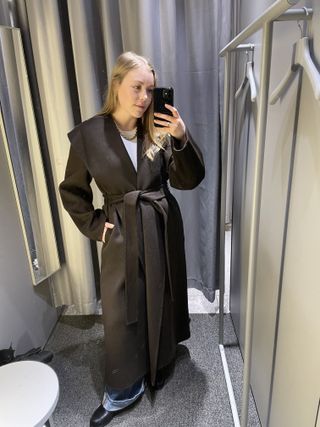 Woman wears brown Arket coat