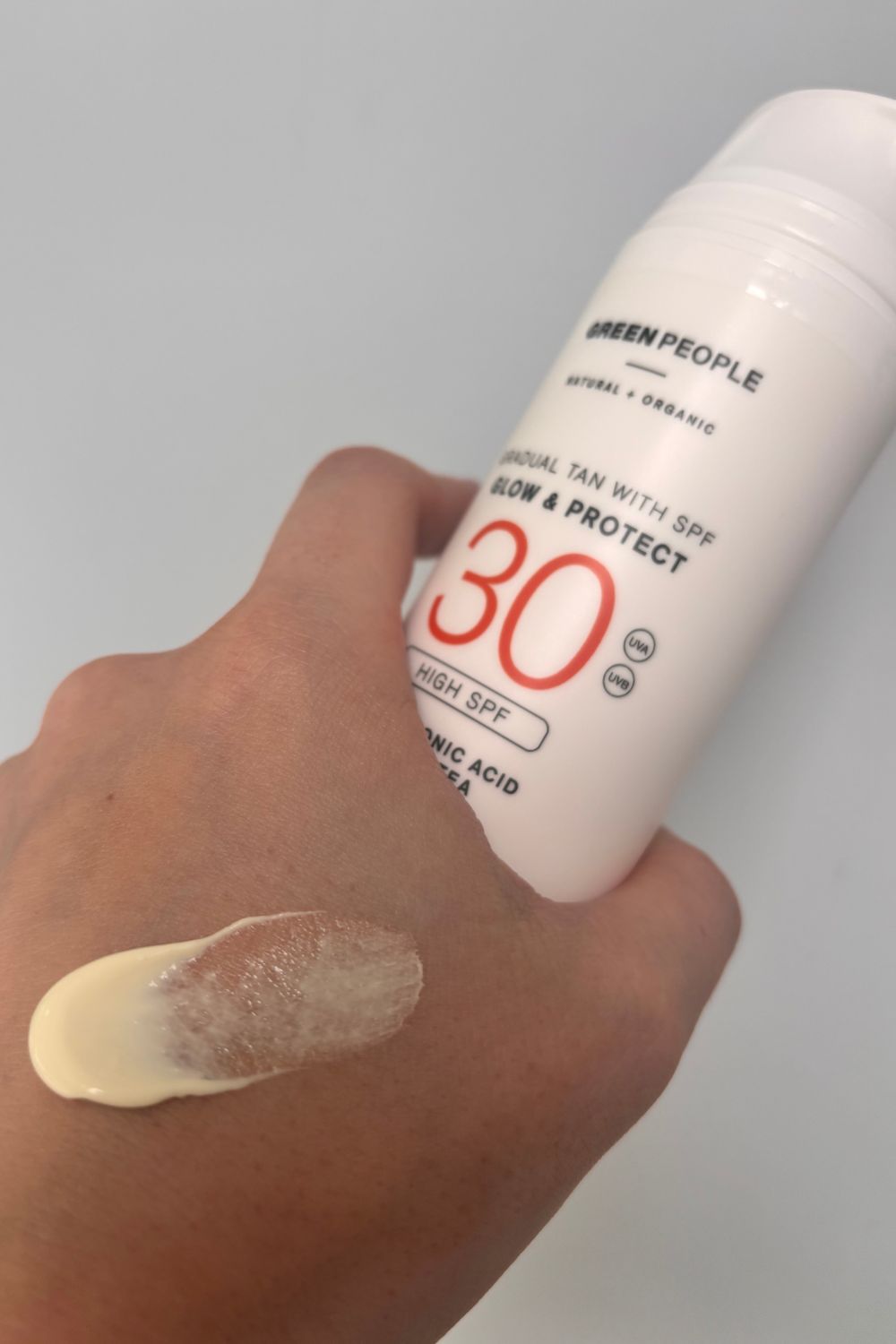 a hand with a smear of green people spf