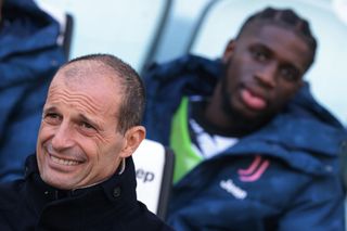 Massimiliano Allegri Head coach of Juventus reacts as Samuel Iling-Junior of Juventus looks on from behind as they sit on the bench prior to kick off in the friendly match between Juventus and HNK Rijeka at Allianz Stadium on December 22, 2022 in Turin, Italy