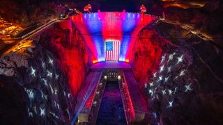 The Hoover Dam lit up in red, white, and blue with the American flag for the 250th anniversary.