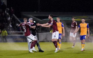 Northampton players attempt to restrain a pitch invader during the League Two play-off semi-final against Mansfield on Wednesday