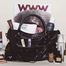 black balenciaga city bag filled with beauty products and a magazine