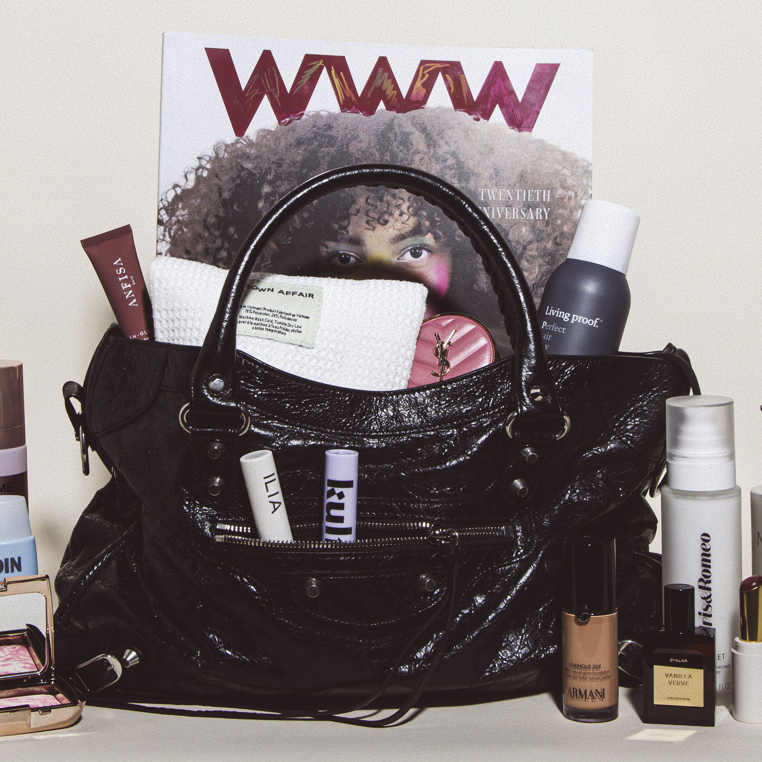 black balenciaga city bag filled with beauty products and a magazine
