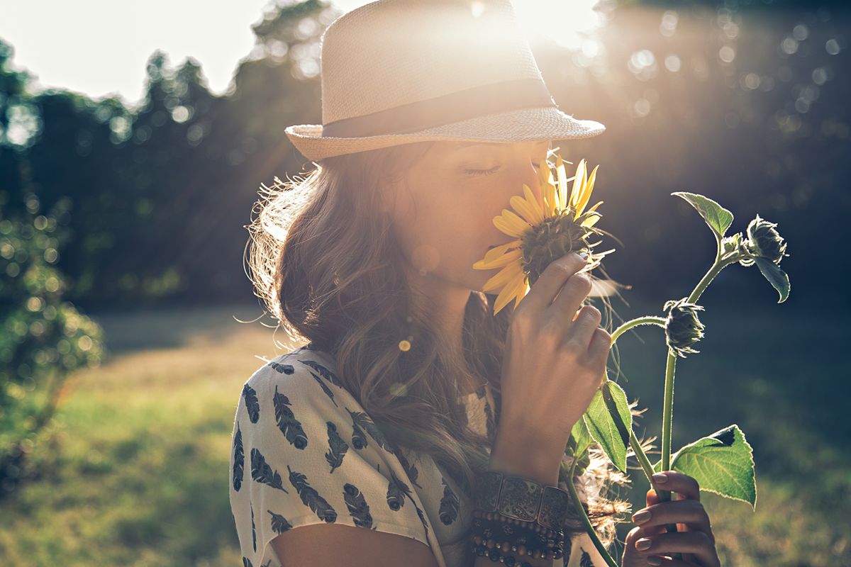 A person smells a sunflower.