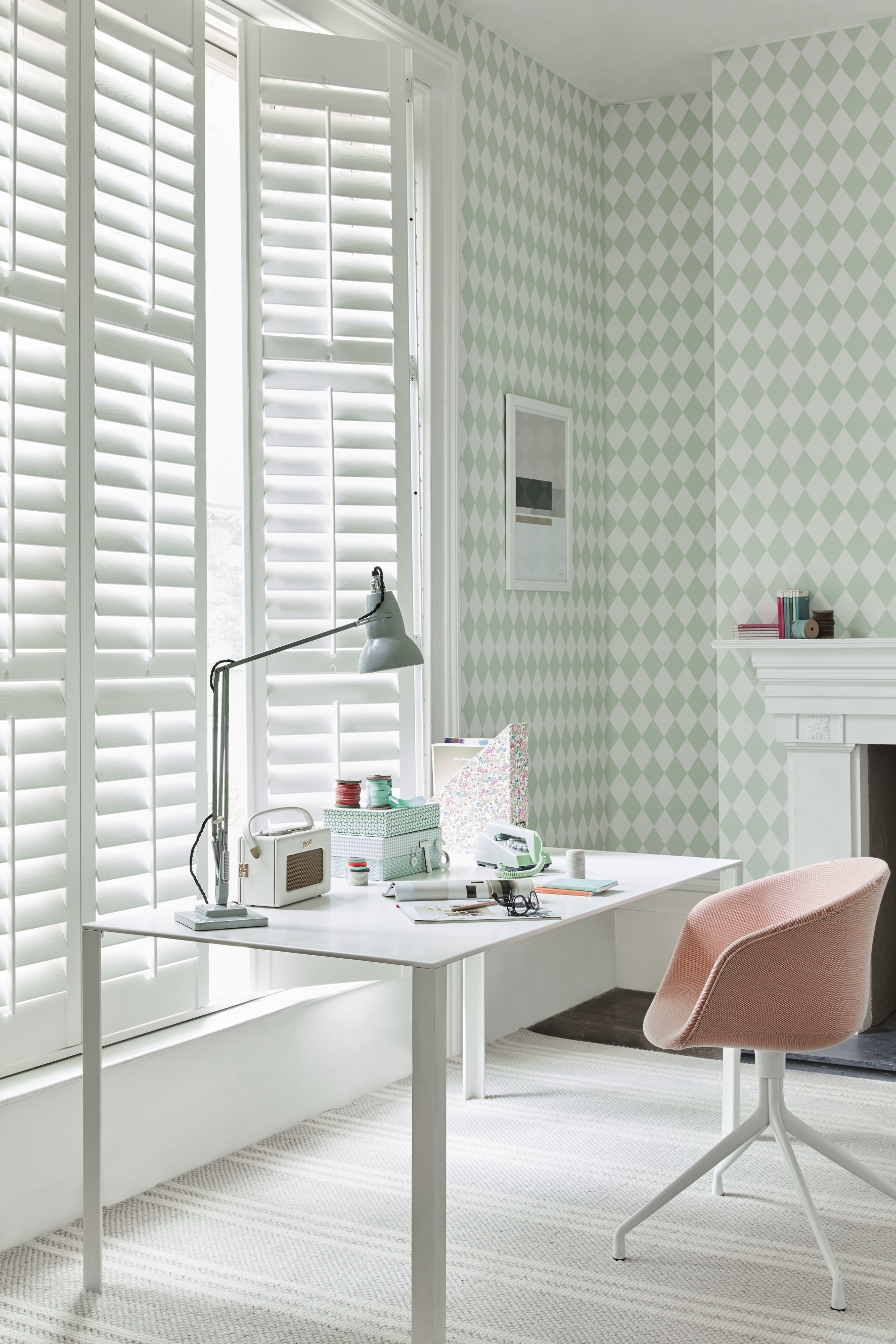 Shutters within a white home office setting by California Shutters – with green and white triangle wallpaper, a white desk, and a pink office chair