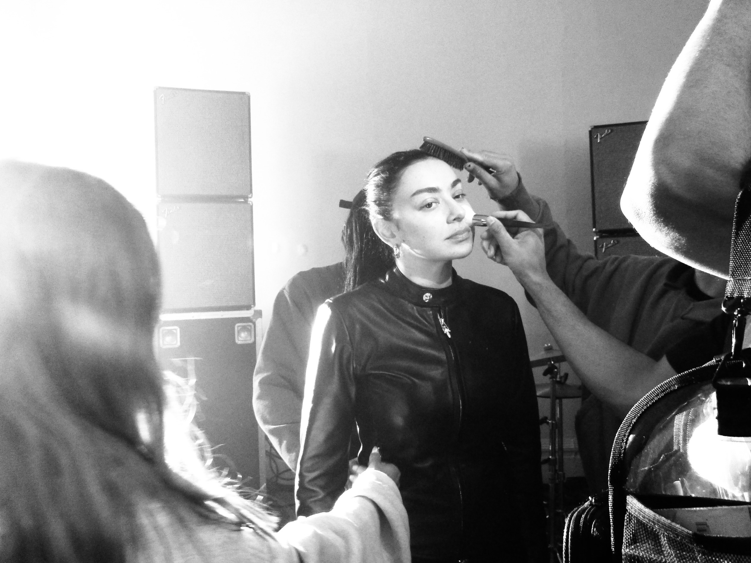 Charli XCX wears a black fitted leather jacket as she gets her make-up applied.