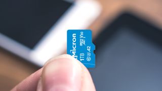 Beste micro SD kort: En person holder et Micron SSD-kort mellom fingrene