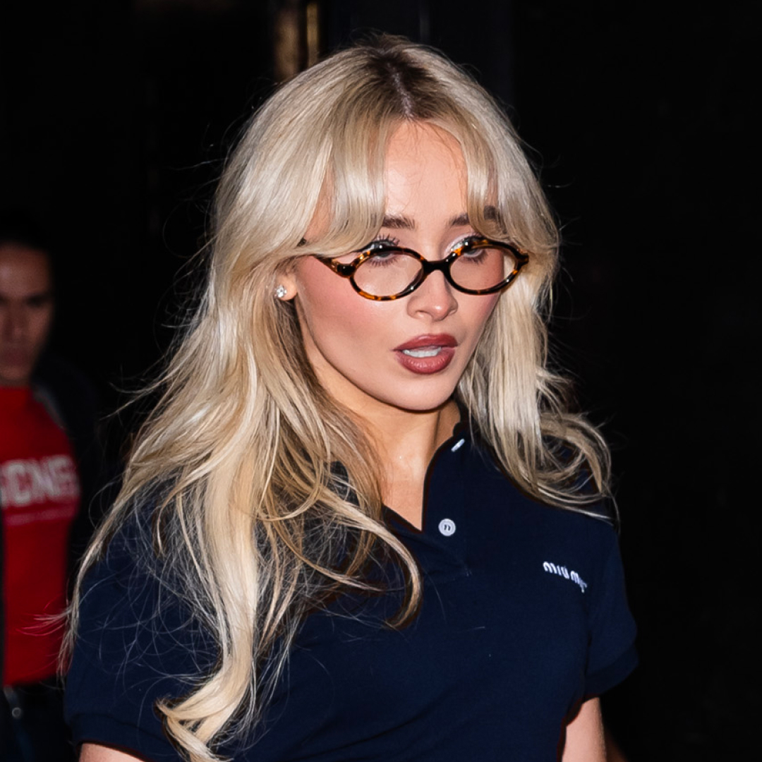 Sabrina Carpenter wearing a black polo shirt with tortoiseshell glasses and long blonde hair