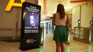 A woman looks at an information kiosk at the airport.