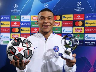 Kylian Mbappe celebrates with the match ball and his Player of the Match award after scoring a hat-trick for Paris Saint-Germain against Barcelona in the Champions League in February 2021.