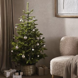 A living room with a teddy sofa and a decorated Christmas tree
