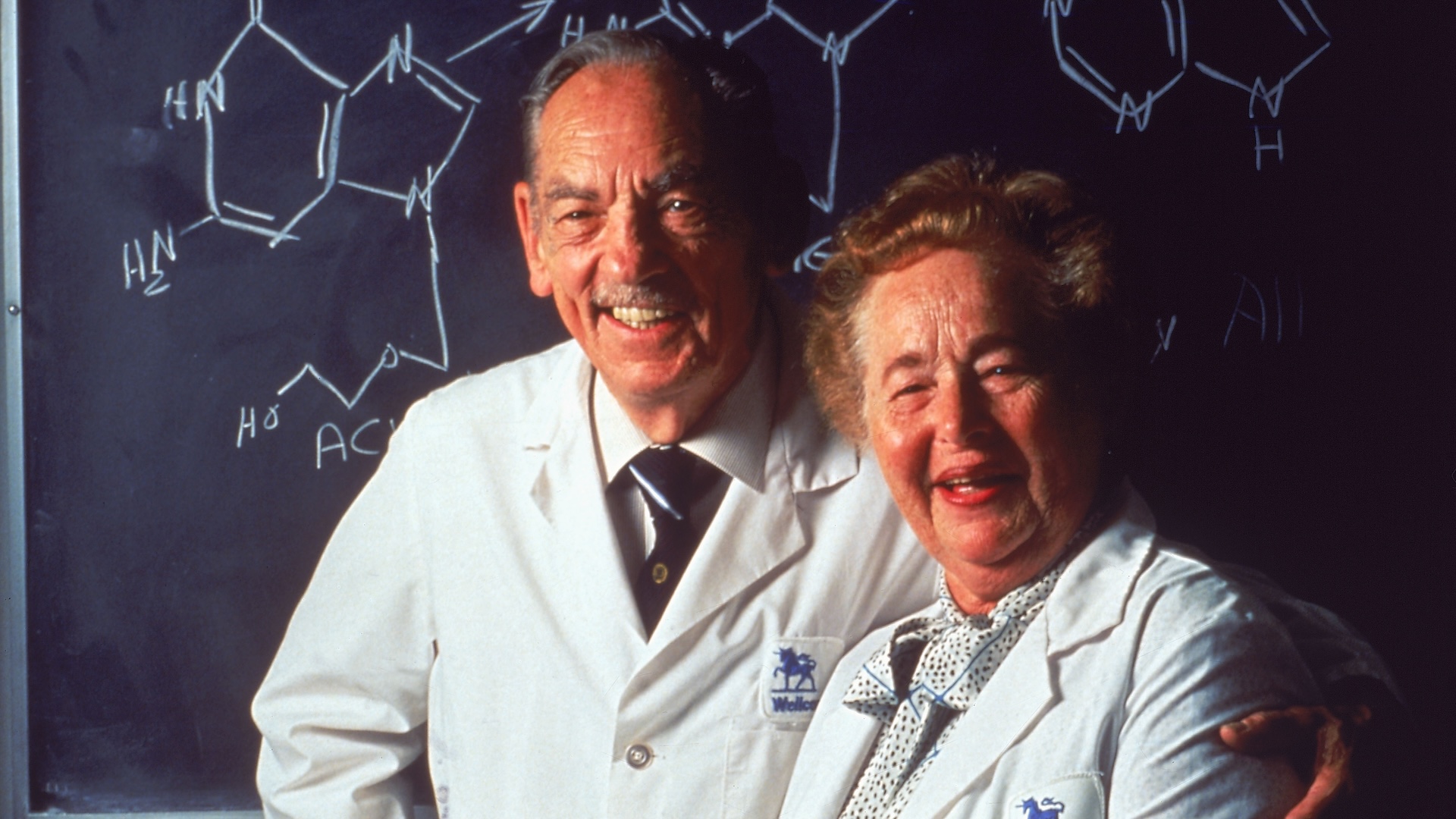 Гертруда Елион и Џорџ Хичингс позирају испред табле 1988