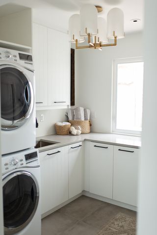 Laundry room with stacked washer and dryer with white supermatte semihandmade cabinet doors