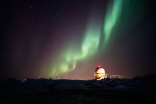 Alaska's northern lights dance above a radar dome