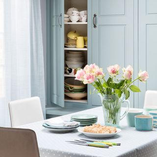 Kitchen with pale blue cupboard and table with chairs