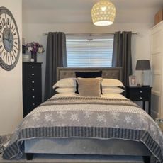 grey and white bedroom with clock and grey curtains