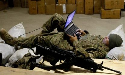 A U.S. soldier uses a laptop while resting after a patrol in eastern Afghanistan on March 5