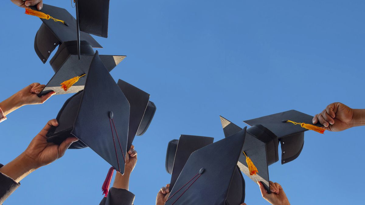 Graduation Pose with hats against blue sky