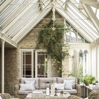 A cream coloured frame conservatory extension featuring rattan furniture