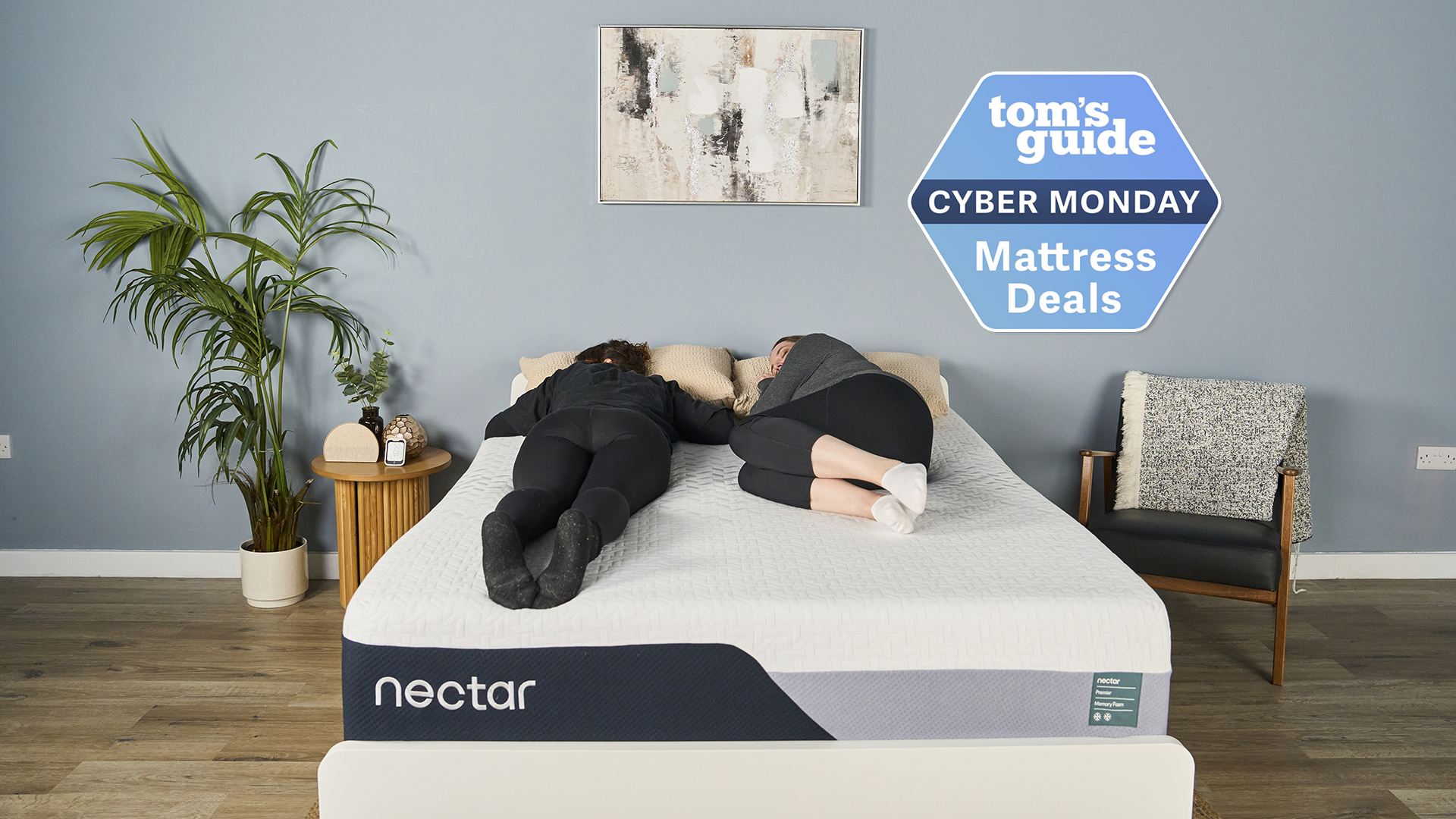The Nectar Premier Memory Foam mattress is on sale for $949 for a queen and here you can see it placed on a white wooden bed frame, with two of our mattress testers lying on top of it