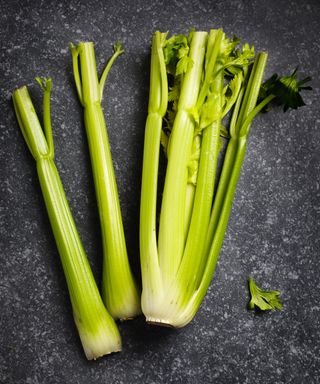 A harvested bunch of celery with one stalk removed