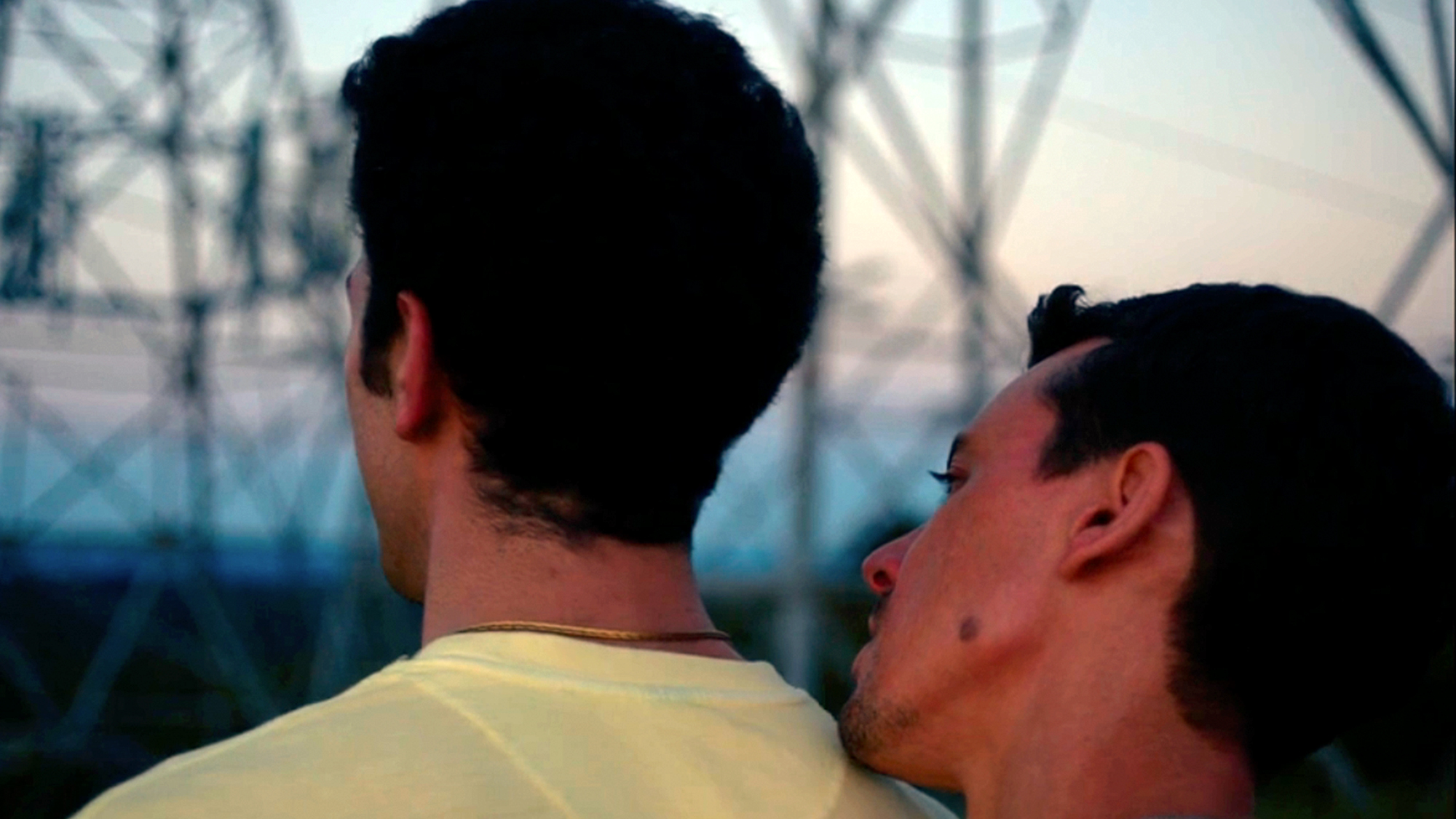 One man leaning into the back of the shoulder of another man in Of An Age