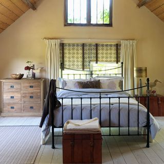bedroom with leather trunk and rustic chest of drawers