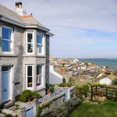 Exterior of house and front garden with garden furniture overlooking the sea.