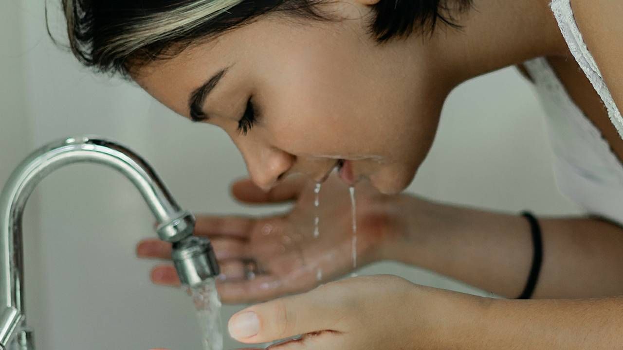 Woman washing her face in the sink