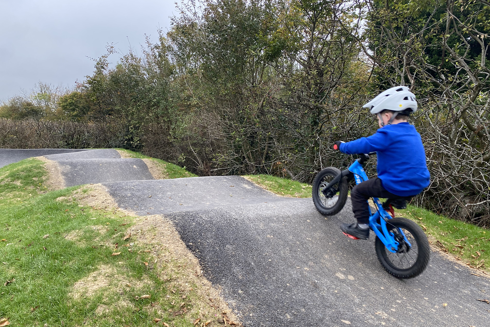 Young boy riding a prevelo Zulu one kids mountain bike at a local pumptrack.