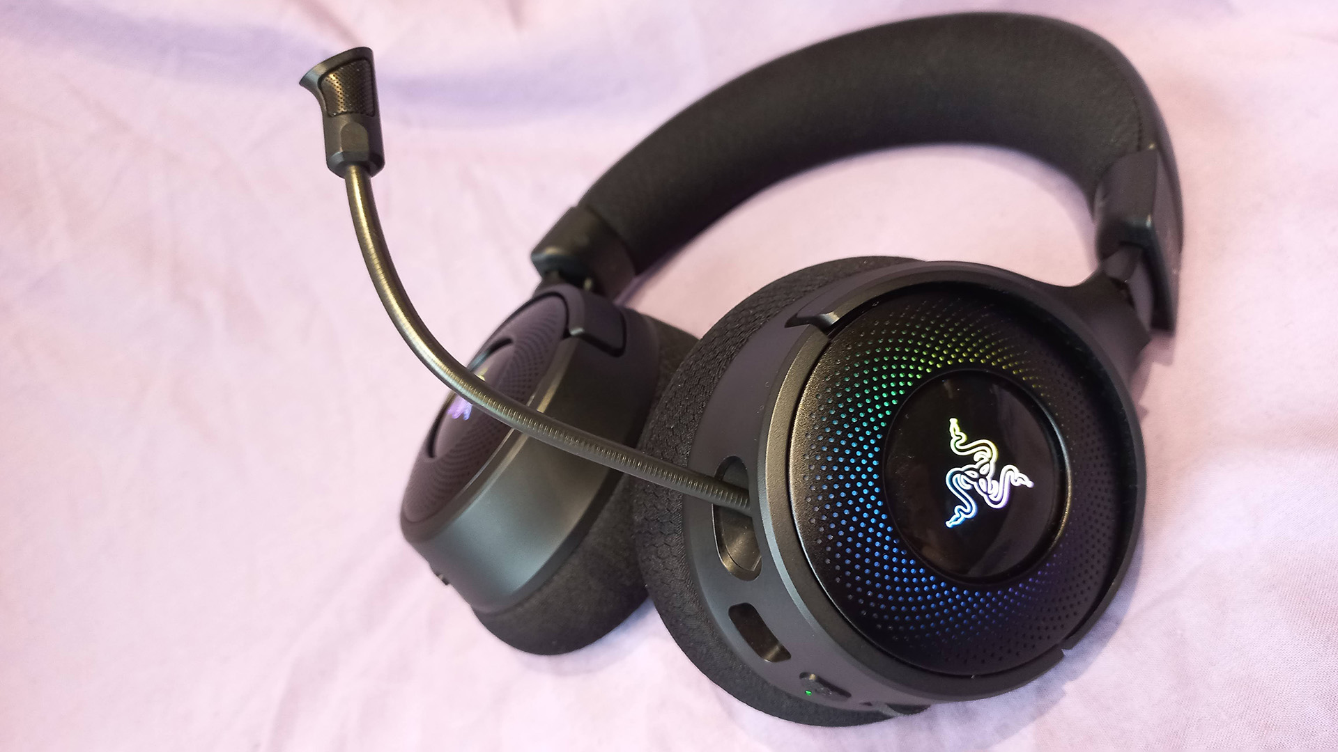 Razer Kraken V4 gaming headset on a cloth background with RGB enabled.