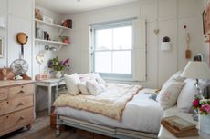 bedroom with pastel bedlinen and bookshelf