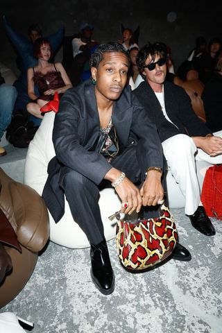 ASAP Rocky at Bottega Veneta RTW Spring 2025 as part of Milan Ready to Wear Fashion Week on September 21, 2024 in Milan, Italy carrying a red snakeskin sardine bag