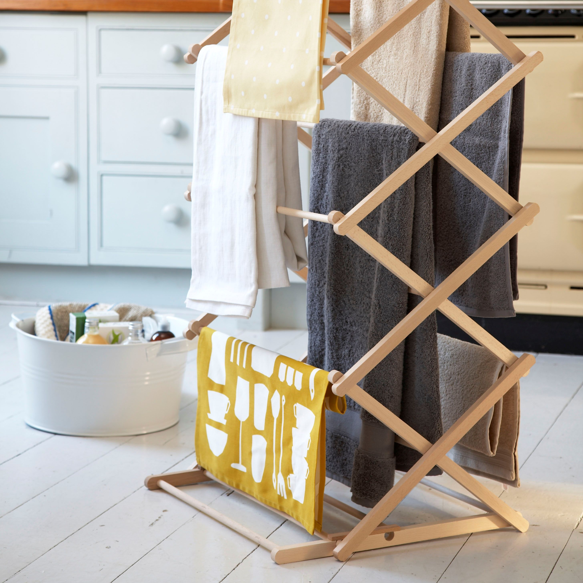 Freestanding wooden towel rail hanging towels in kitchen