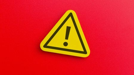 A yellow caution triangle against a red background.
