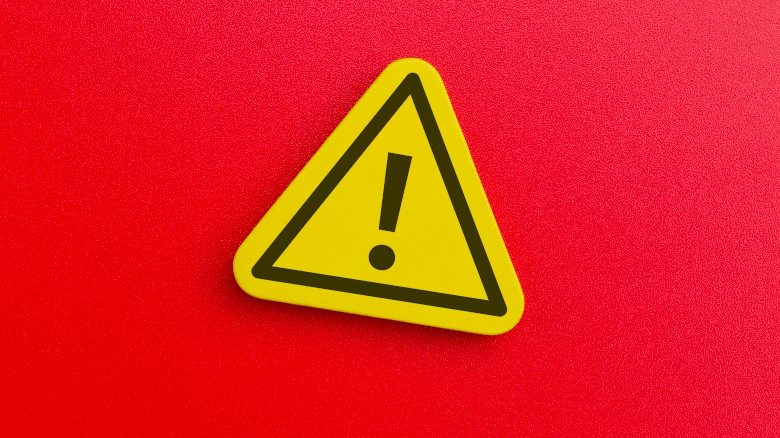 A yellow caution triangle against a red background.