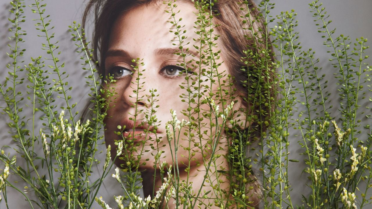 An image of a woman&#039;s face with wild flowers collaged over the top