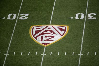 The Pac-12 logo on a football field.