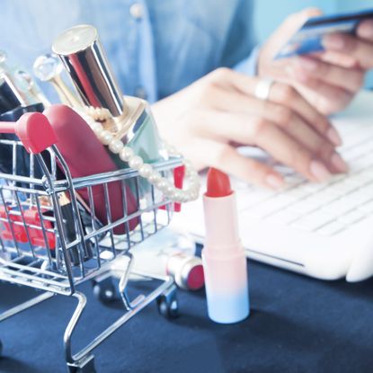 woman on her computer next to beauty products