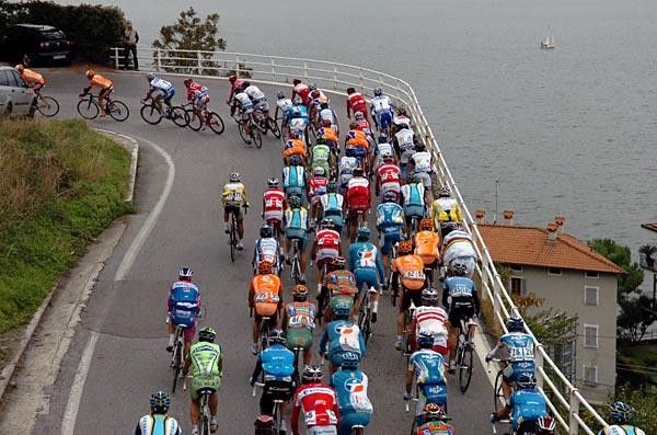 The peloton rides away from the Lake up into the hills.