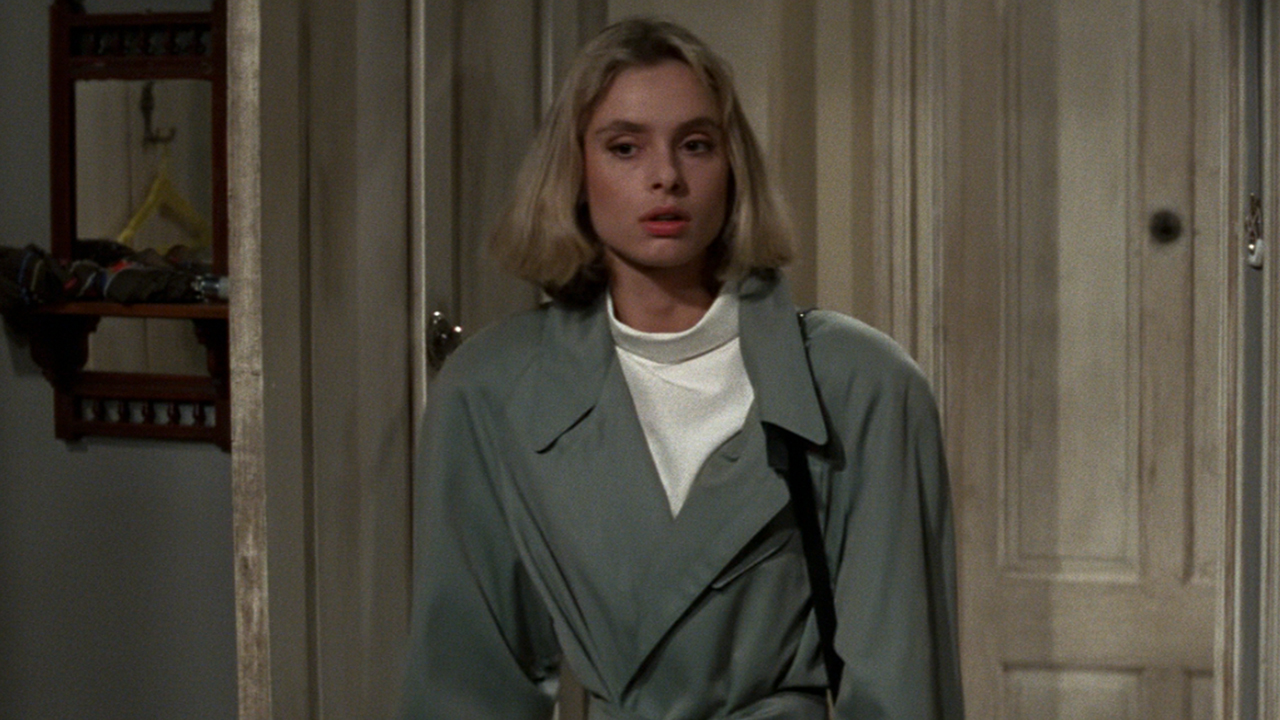 Maryam d'Abo in a grey overcoat looking suspicious in The Living Daylights