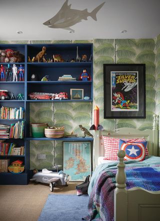 How to organize a kid's room with palm print wallpaper and built in blue shelves