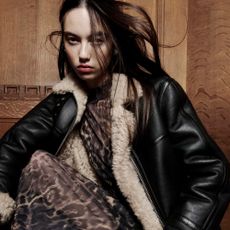 Model wearing a fur lined leather jacket and animal print AllSaints dress