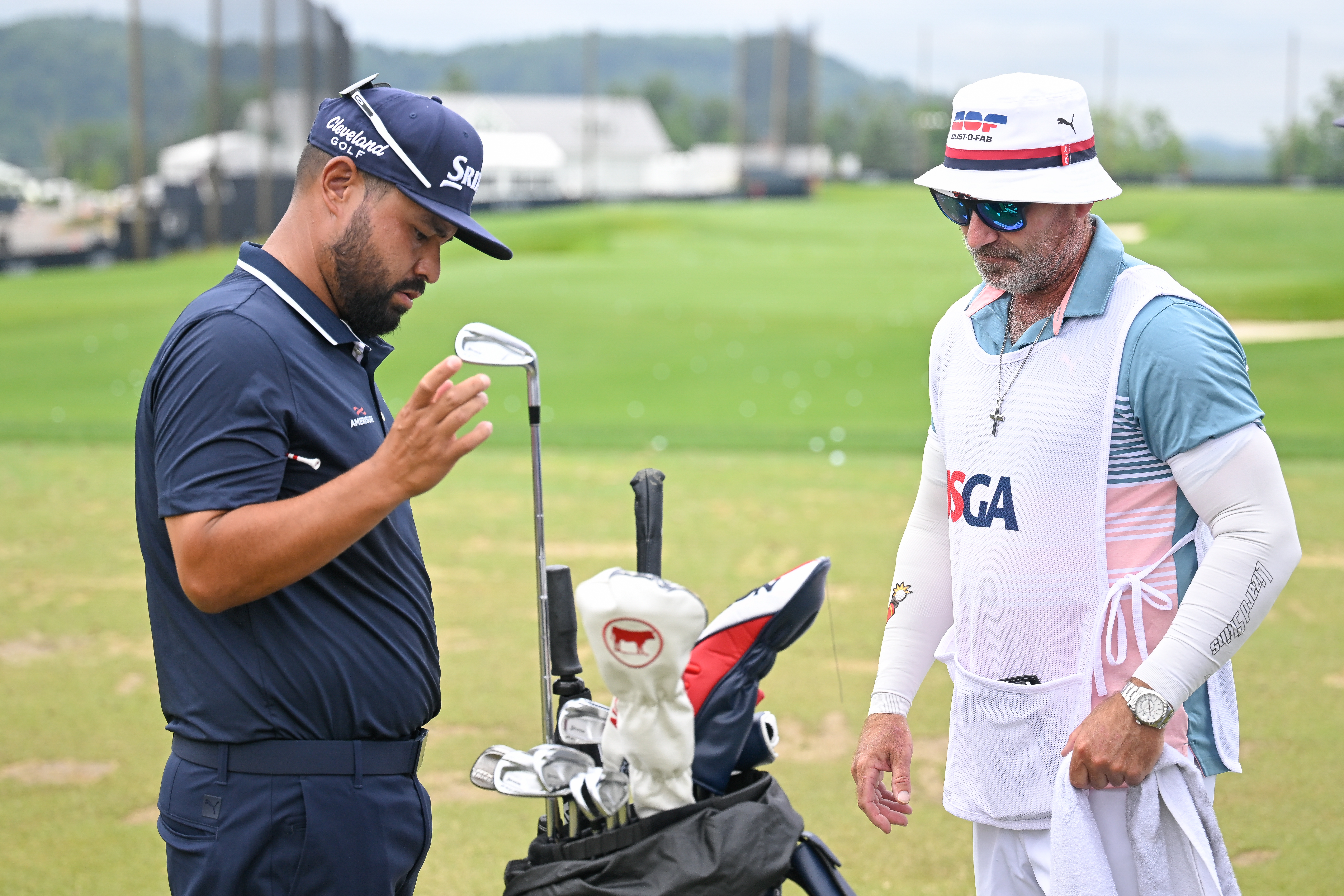 JJ Spaun pulls a club out of his bag