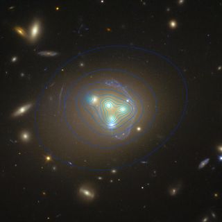 The distribution of dark matter in the galaxy cluster Abell 3827 appears as blue contour lines in this view from the Hubble Space Telescope.