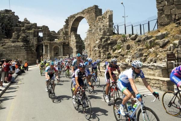 The peloton rolls through some ruins