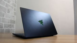 Image shows the Razer Blade 14 gaming laptop on a wooden table.