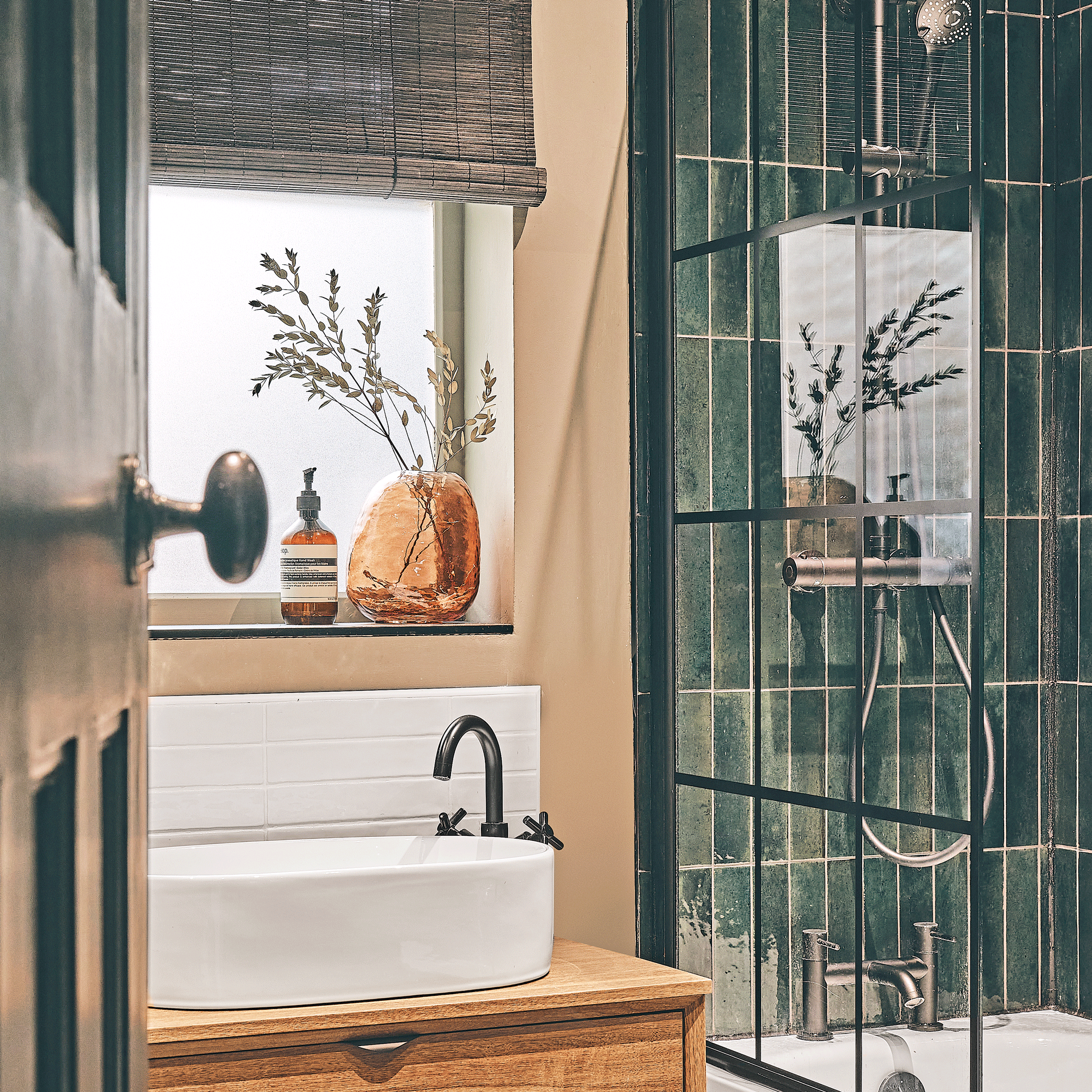 a bathroom with a shower bath and vertical green metro tiles