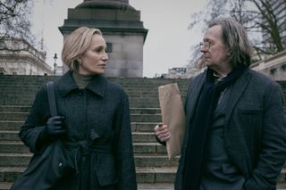 (L to R) Kristin Scott Thomas as Diana Taverner and Gary Oldman as Jackson Lamb stand on steps in conversation in Slow Horses