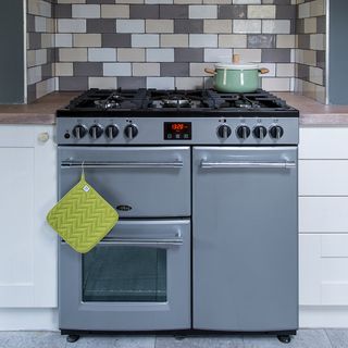 kitchen area with grey stove and oven and tiles floor
